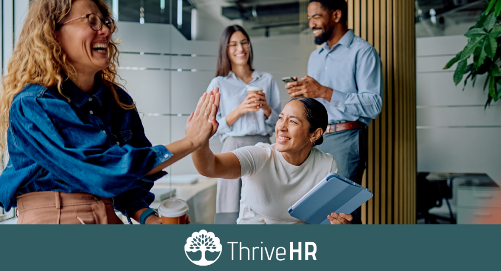 Diverse HR team celebrating successful hiring and workplace collaboration in a modern office