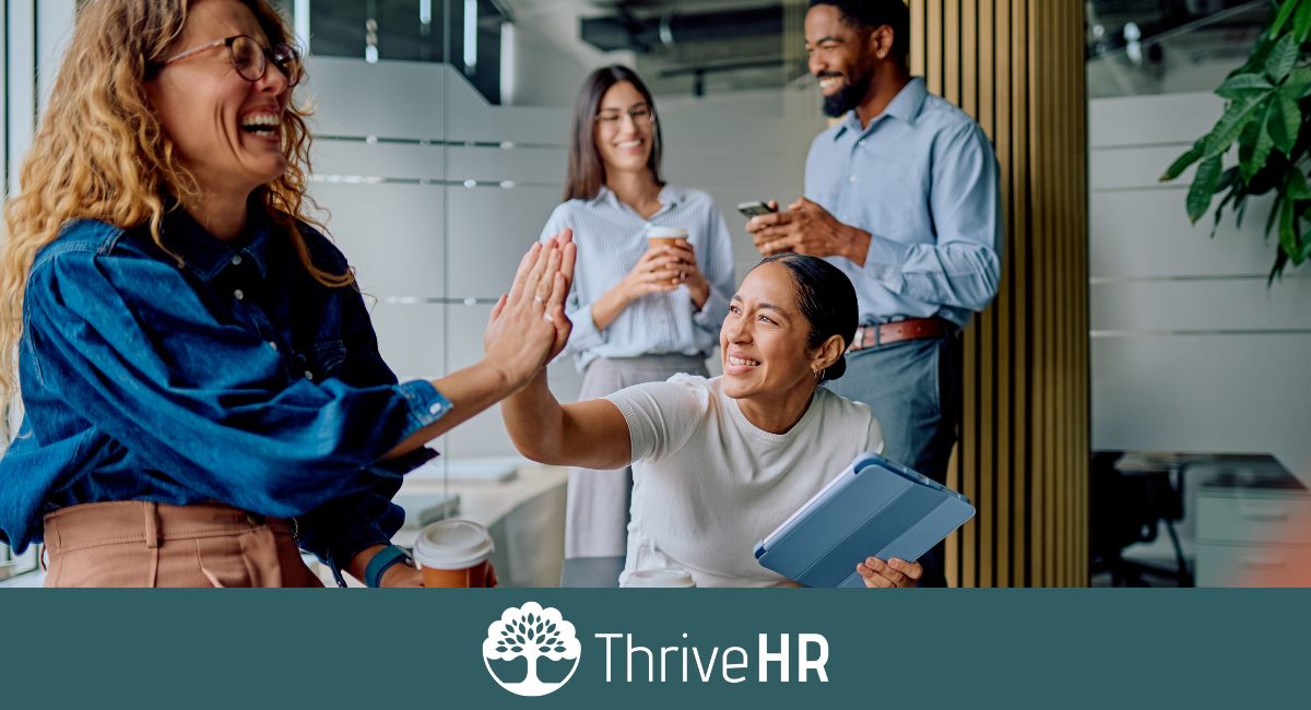 Diverse HR team celebrating successful hiring and workplace collaboration in a modern office
